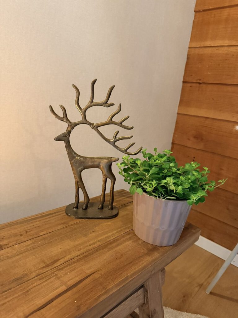 Detail in De Loods, een bronzen hert op een houten bankje